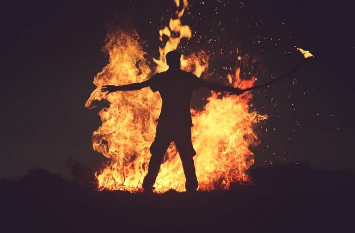 Ein Mann steht vor einem Feuer.