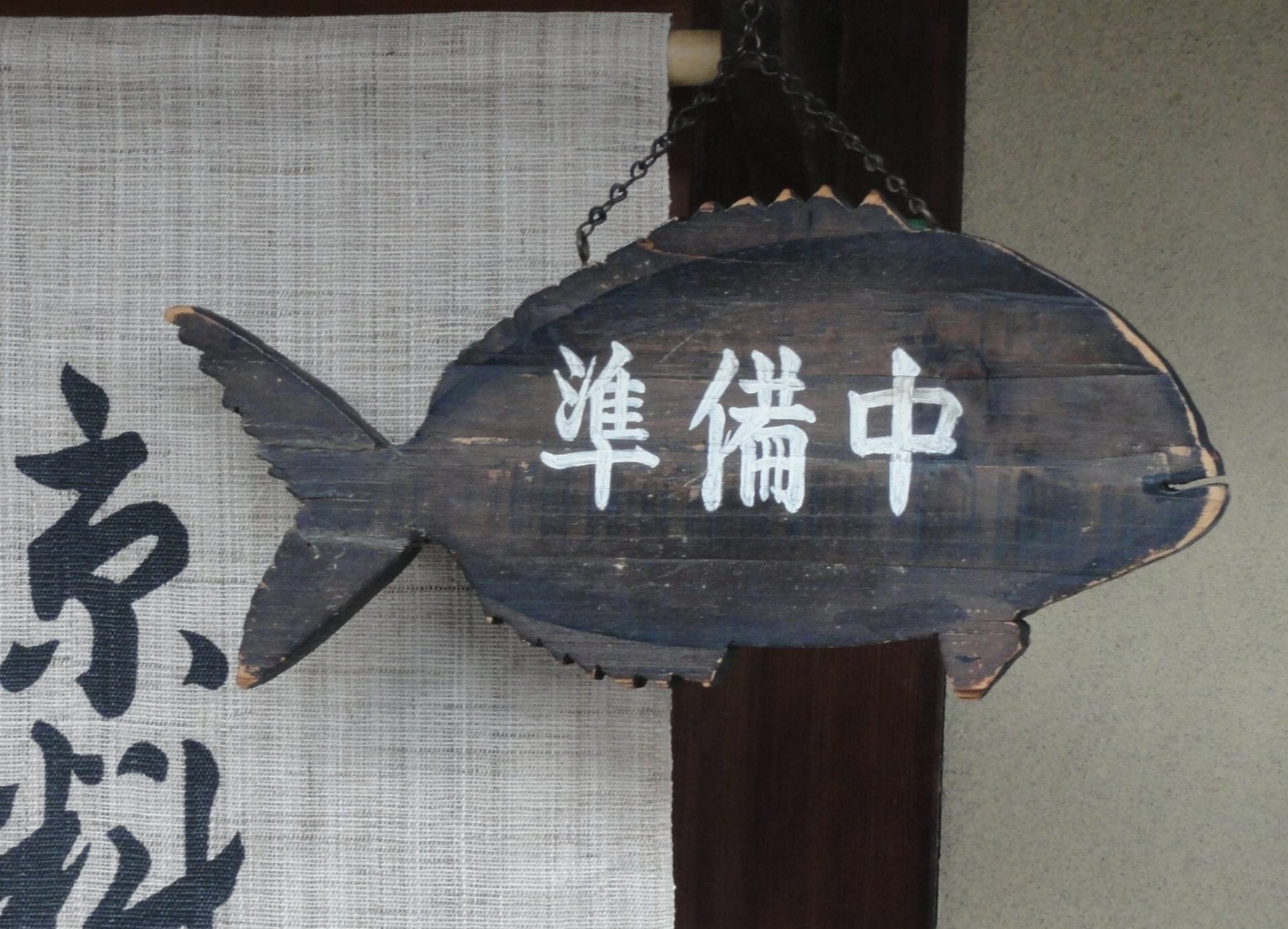 Ein Kanban-Holzschild, an dem ein Fisch hängt.