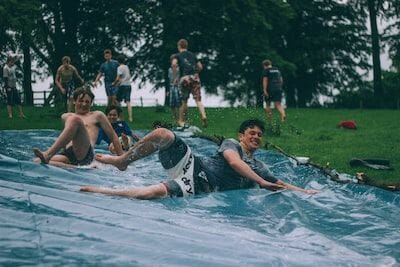 Eine Gruppe von Menschen spielt auf einer Wasserrutsche in einem Park.