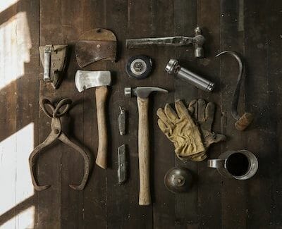 Auf einem Holzboden liegen verschiedene Werkzeuge ausgelegt.