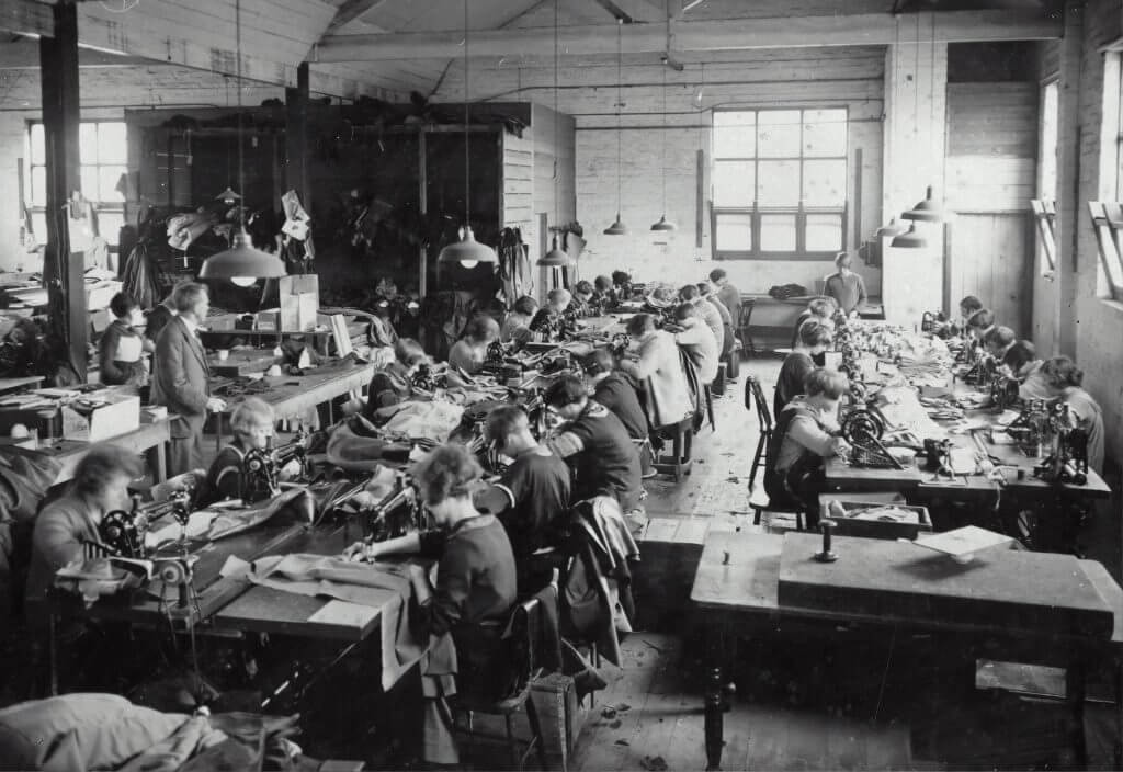 Ein Schwarz-Weiß-Foto von Menschen, die in einer Fabrik arbeiten.
