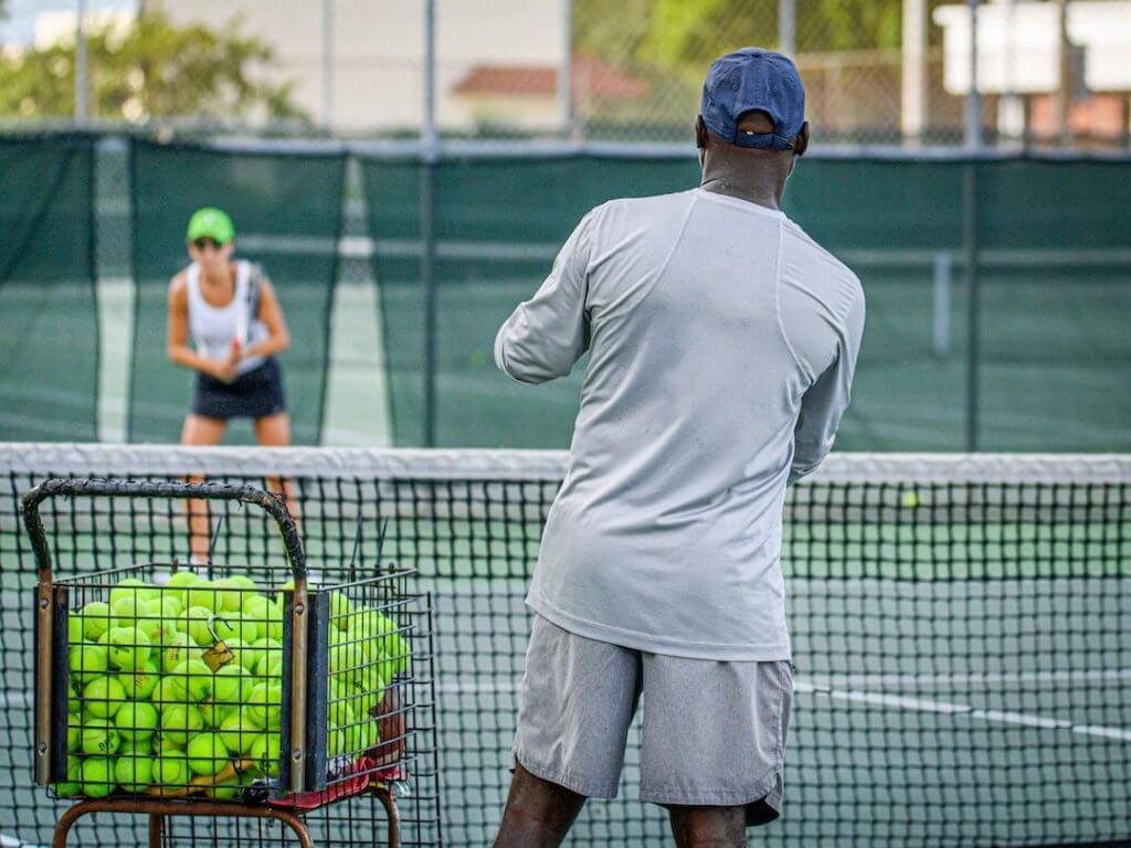 Ein Mann steht mit einem Schläger auf einem Tennisplatz.